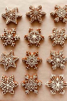 twelve snowflake cookies are arranged on a sheet of paper