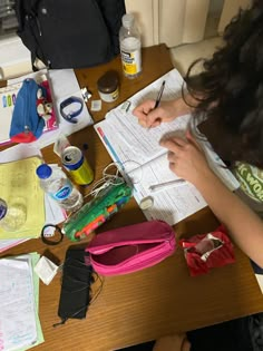 a person sitting at a table with some papers and other items on top of it