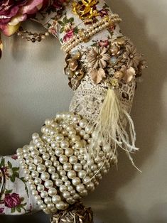 a close up of a wreath made out of pearls and other things on a wall