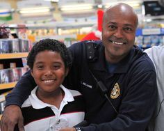 a man is holding a young boy in a store while he smiles at the camera