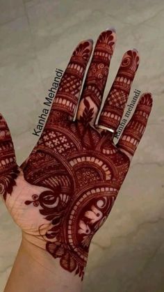 the hand is decorated with red henna