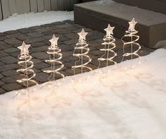 a row of christmas lights sitting on top of snow covered ground