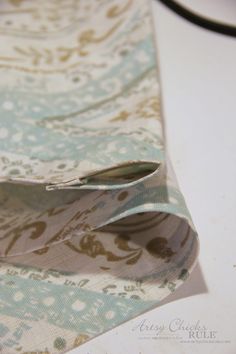 a close up of a tie laying on top of a white table with blue and brown designs