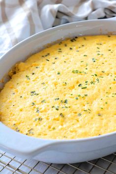 a casserole dish with cheese and herbs in it on a wire cooling rack