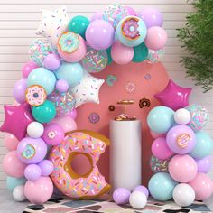 a balloon arch with doughnuts, balloons and confetti