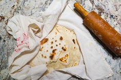 an uncooked tortilla next to a rolling pin