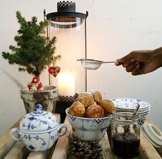 a table topped with bowls filled with food and a teapot next to a candle