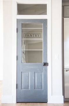 the pantry door is painted blue and has an open shelf above it that says pantry