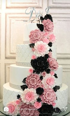 a wedding cake decorated with pink and black flowers