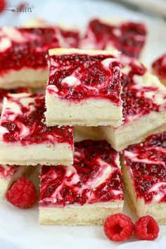 white chocolate raspberry cheesecake bars stacked on top of each other