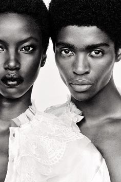 two black women with short hair are posing for the camera, one is staring at the camera