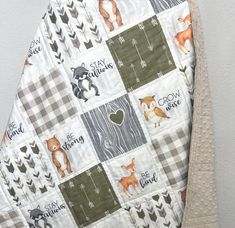 a close up of a baby quilt with animals on it and words that say stay wild