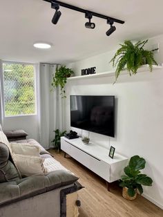 a flat screen tv sitting on top of a white entertainment center in a living room