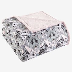 an elephant print blanket is folded on top of a white sheet with pink linings