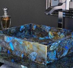 a bathroom sink that is made out of blue and gold marbles with a chrome faucet