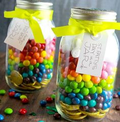 two glass jars filled with colorful candy on top of a blue plate next to each other