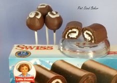 chocolate cake pops with white frosting on top in a box and some other candies