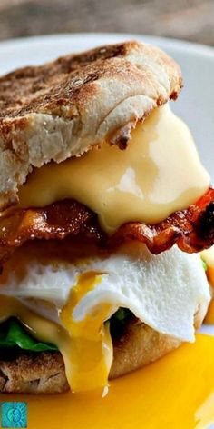 an egg, bacon and cheese sandwich on toasted bread with melted cheese in the middle