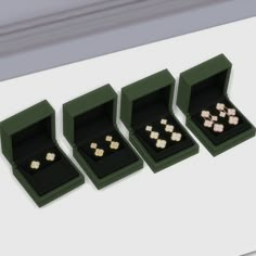 three boxes with gold rings in them sitting on a white countertop next to each other