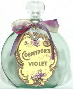 a glass bottle with a bow on the top that says cosmydor's violett