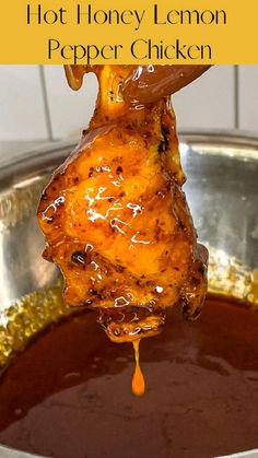 honey lemon pepper chicken is being lifted from a pot with sauce on it and the words, hot honey lemon pepper chicken