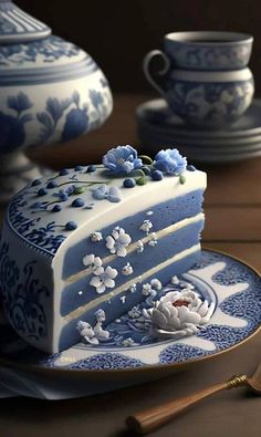 a blue and white cake sitting on top of a plate next to two tea cups