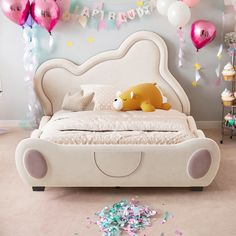 a bed with balloons and confetti on the floor