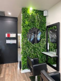 a salon with green walls and chairs in front of the wall that says evave beauty