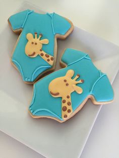 three decorated cookies in the shape of giraffes