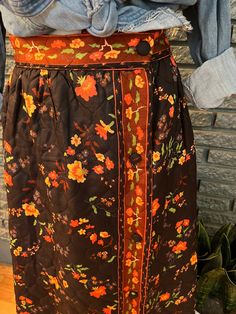 a woman's skirt with an orange flowered design on the front and side