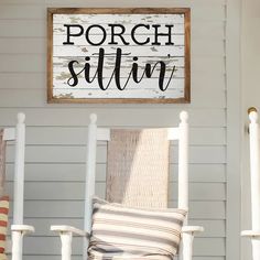 a porch sign that says porch sitin on top of a white rocking chair with a striped pillow