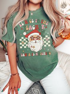 a woman with long blonde hair wearing a santa clause t - shirt