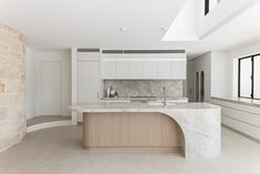 a large kitchen with marble counter tops and an island in front of a window that looks out onto the outside