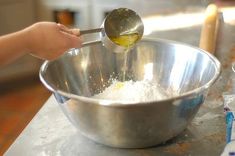 a person mixing something in a metal bowl