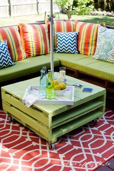 an umbrella is sitting on top of a coffee table in the middle of a patio