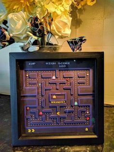 a framed video game is shown with flowers in the background