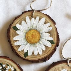 three wood slices with flowers painted on them