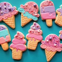 ice cream cookies decorated with sprinkles and icing on a blue background