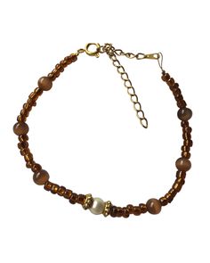 This handcrafted beaded bracelet was created using dark brown glass beads, dark brown opal Catseye beads, white round pearl beads, and Tibetan gold flower cap beads. Luxury Handmade Brown Jewelry, Luxury Brown Bracelets With 8mm Beads, Luxury Brown Beaded Bracelets, Luxury Brown Round Bead Bracelets, Wire Bracelet, Gold Flower, Beads And Wire, Beads Bracelet, Gold Flowers