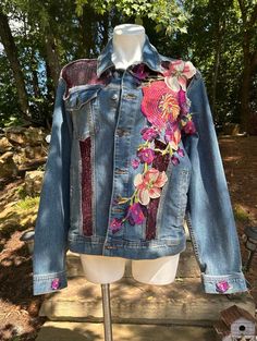 a denim jacket with floral appliques on it