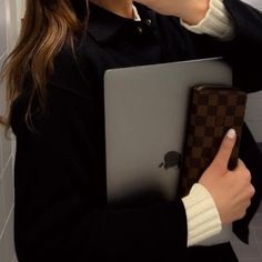 a woman holding an apple laptop in her hands