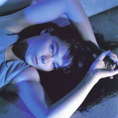 a woman is laying on the floor with her hands in her hair and eyes closed