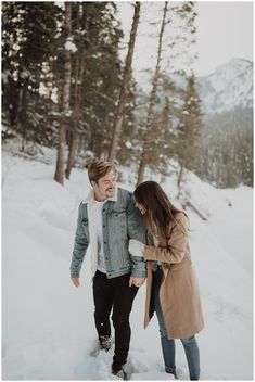 a man and woman walking through the snow