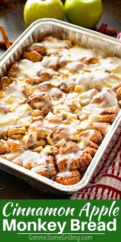 cinnamon apple monkey bread in a baking pan with apples and cinnamon sticks around the edges