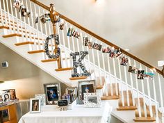 a table with pictures on it under a stair case next to a white banister