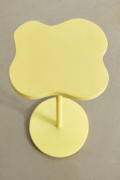 a yellow table with a round base on the top that is shaped like a flower