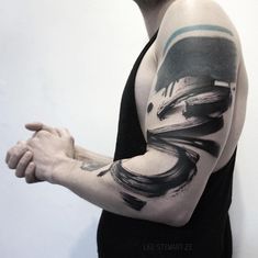 a man's arm with black and grey ink art work on his left arm