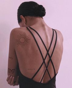 the back of a woman's body with tattoos on her upper and lower arm