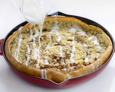 a person pouring milk into a pie in a pan