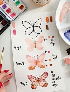 someone is painting butterflies with watercolors on paper